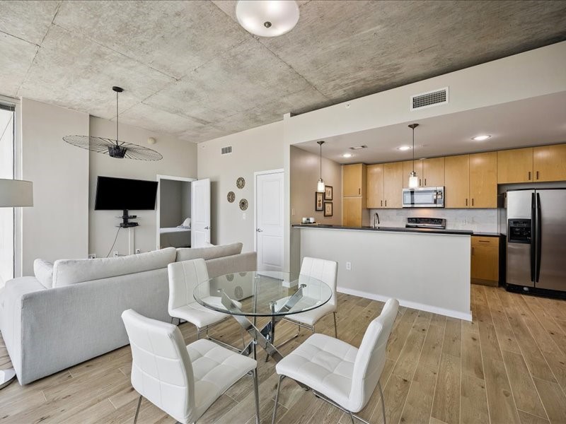 5925 Almeda Road, Unit 12202 Houston, TX 77004 - Photo 3 of 33 Spacious dining area with floor-to-ceiling windows and an open flow into the kitchen and living room. The modern layout maximizes natural light while offering incredible views of the Houston skyline.