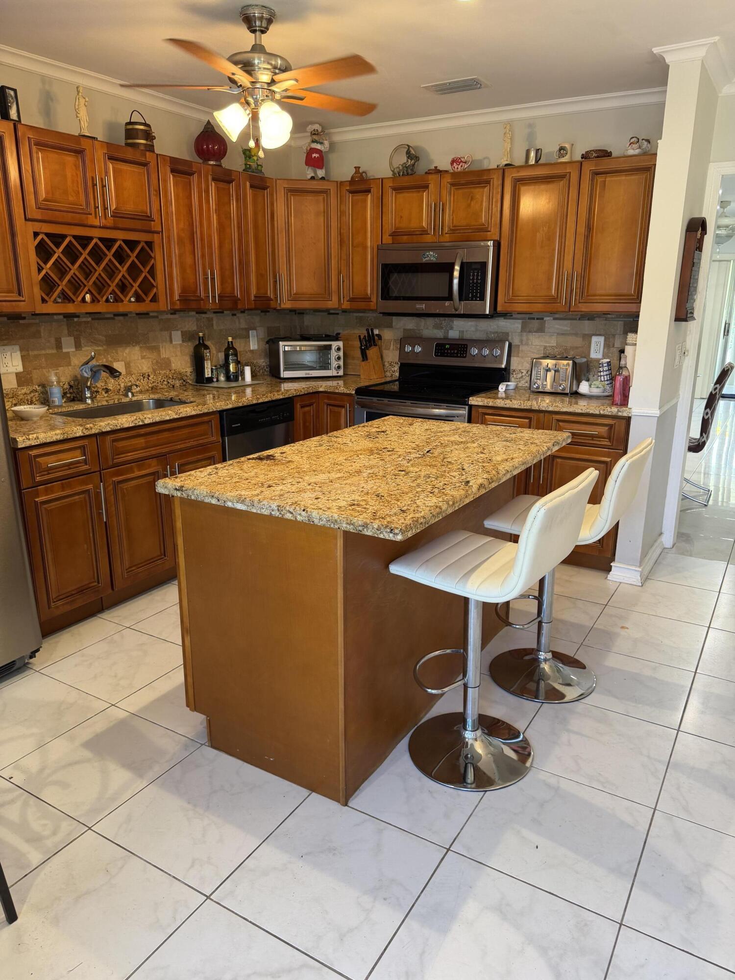 8588 Bella Vista Drive Boca Raton, FL 33433 - Photo 3 of 12 a kitchen with stainless steel appliances a stove a sink and a refrigerator