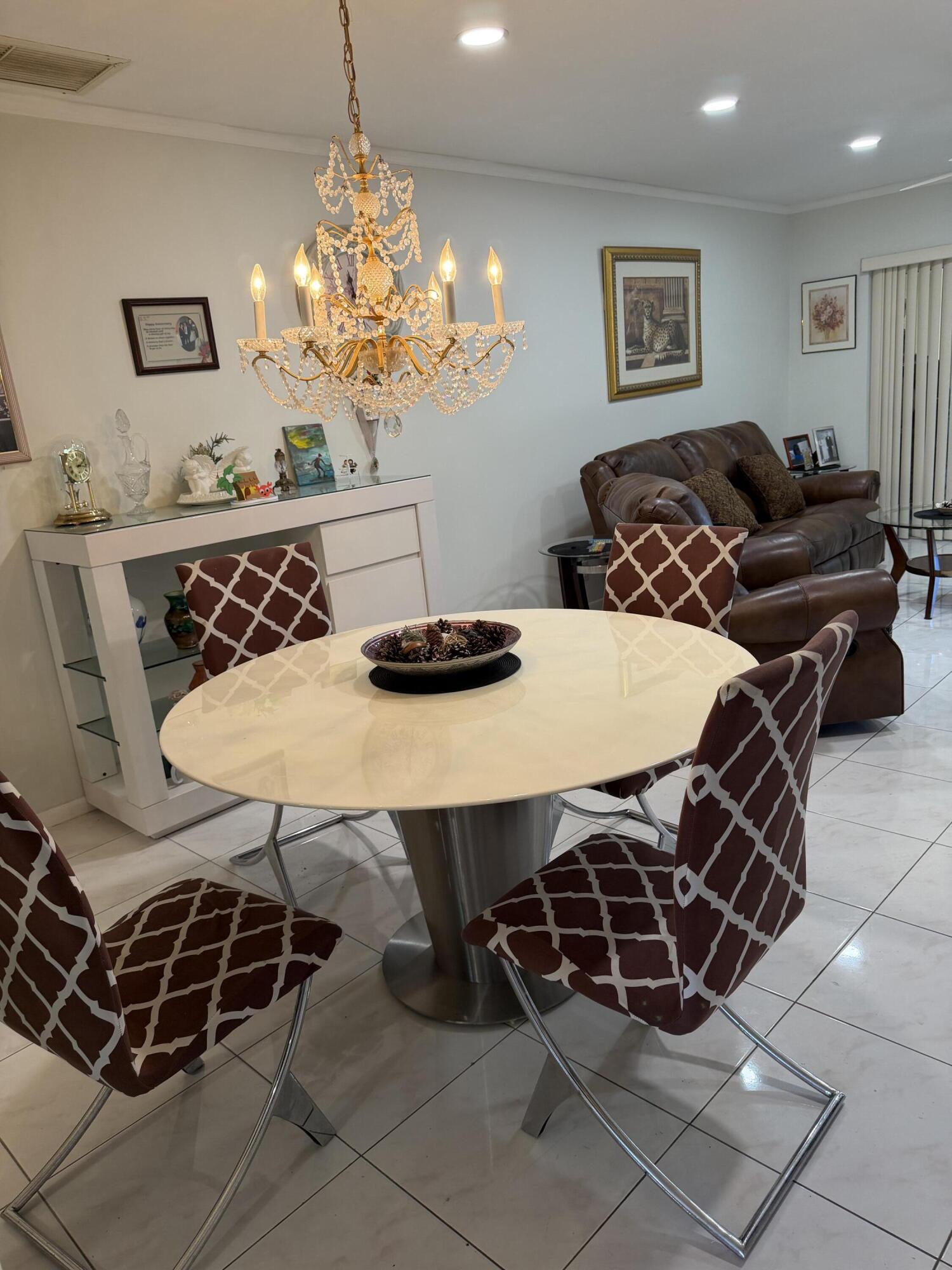 8588 Bella Vista Drive Boca Raton, FL 33433 - Photo 4 of 12 a living room with furniture a chandelier and a dining table