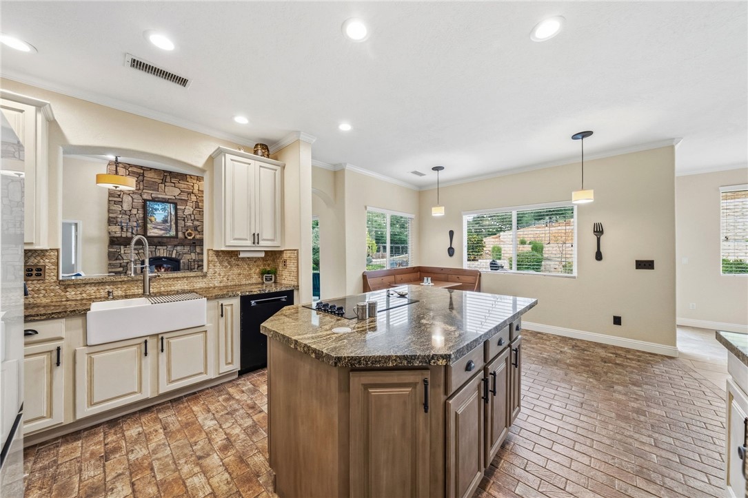 45600 La Cruz Drive Temecula, CA 92590 - Photo 28 of 75 a kitchen with kitchen island granite countertop a sink stove and wooden cabinets