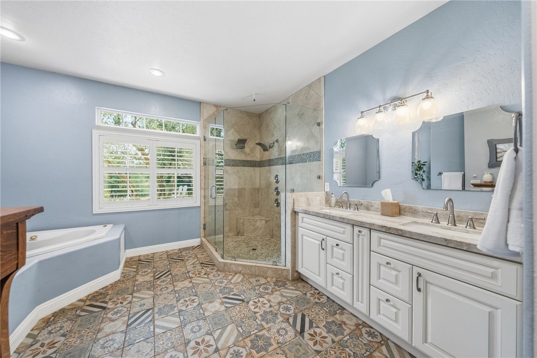 45600 La Cruz Drive Temecula, CA 92590 - Photo 47 of 75 a spacious bathroom with a double vanity sink a large mirror and a bathtub