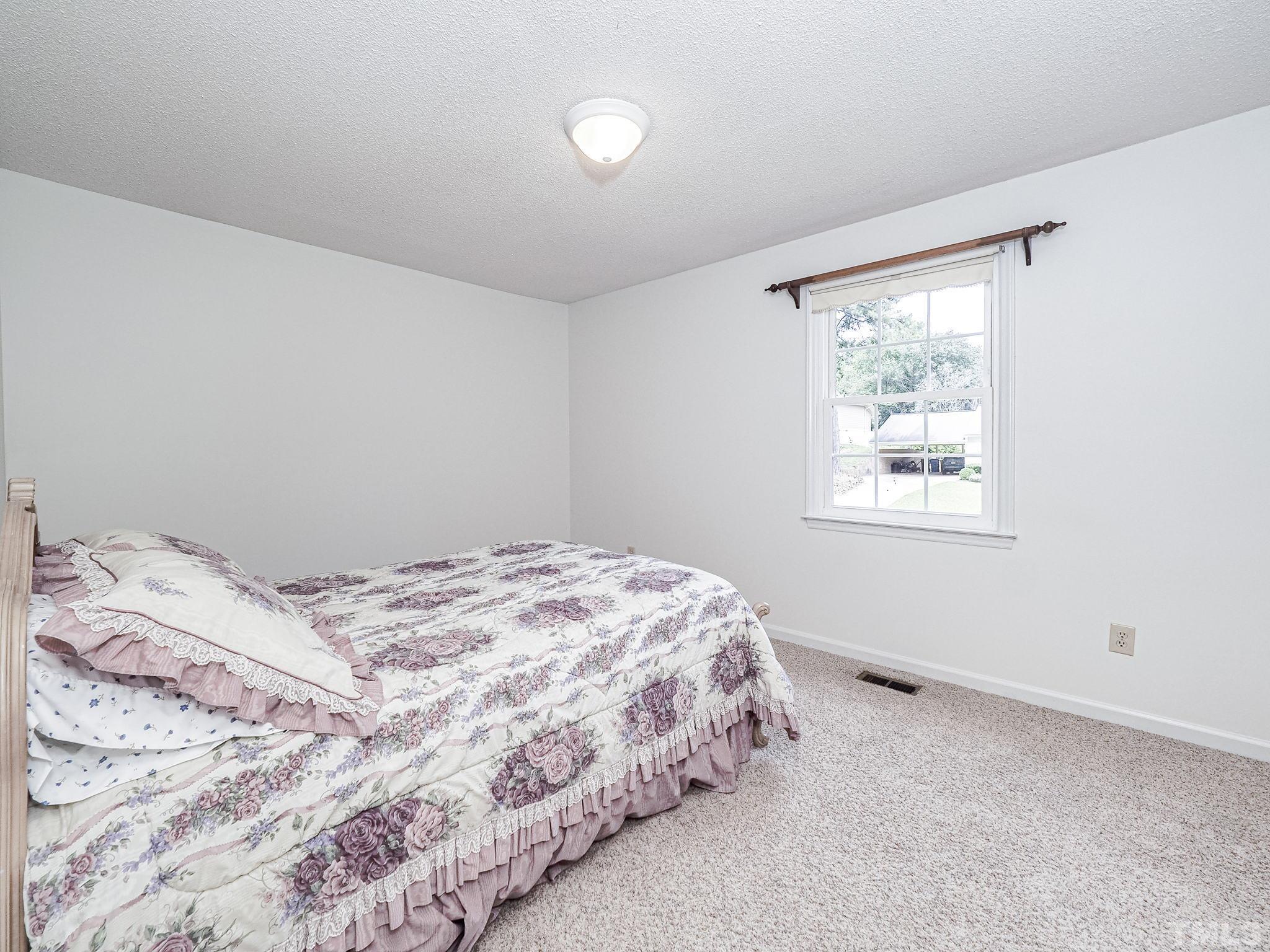 2624 Catalina Drive Raleigh, NC 27607 - Photo 24 of 35 a bedroom with a bed and a window