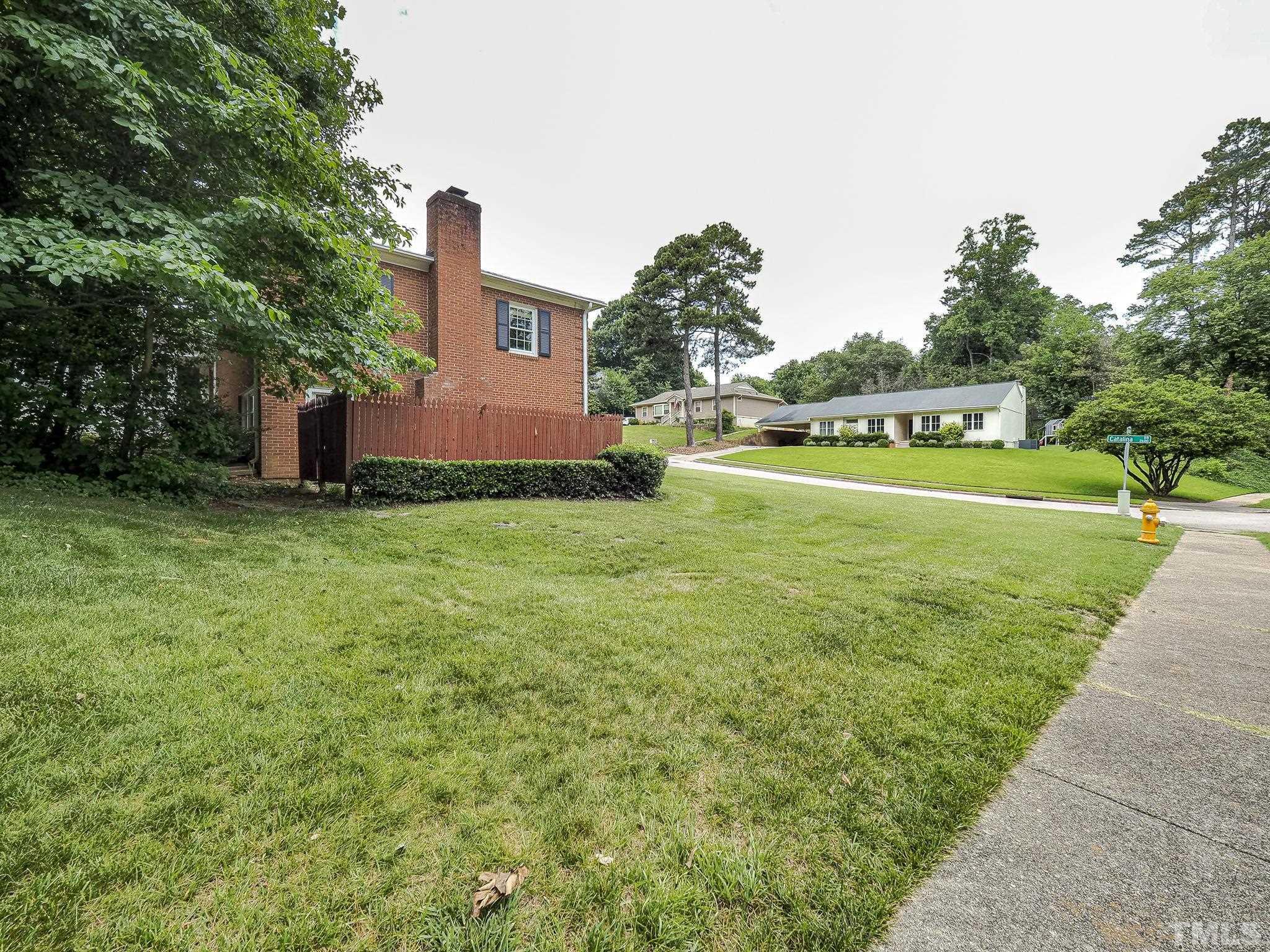 2624 Catalina Drive Raleigh, NC 27607 - Photo 34 of 35 a view of a big house with a big yard and large trees