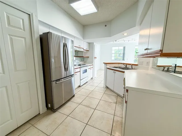 a kitchen with stainless steel appliances a refrigerator sink and cabinets