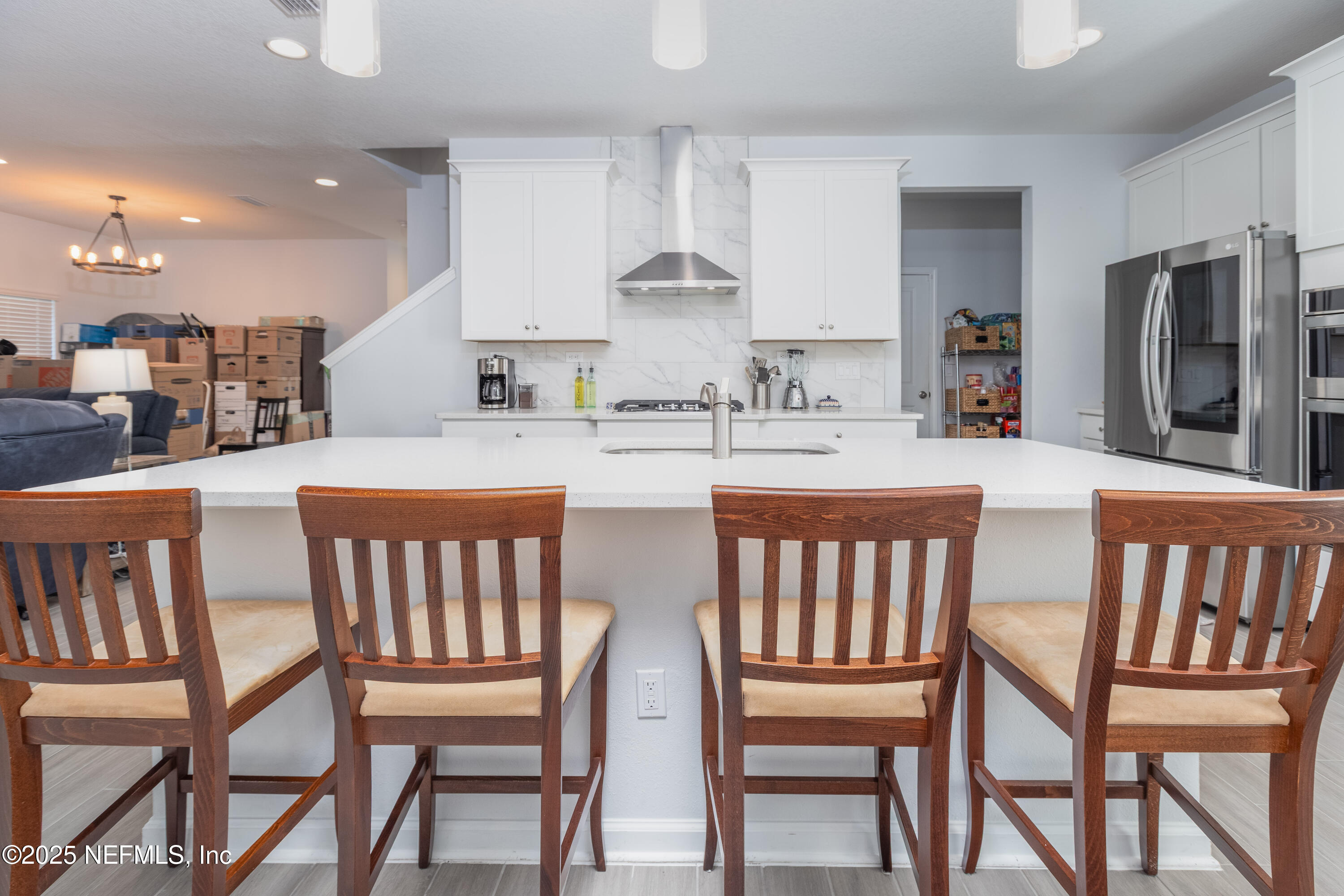 54 Wiltshire Drive St. Augustine, FL 32092 - Photo 4 of 23 a kitchen with stainless steel appliances kitchen island granite countertop a dining table chairs and a refrigerator