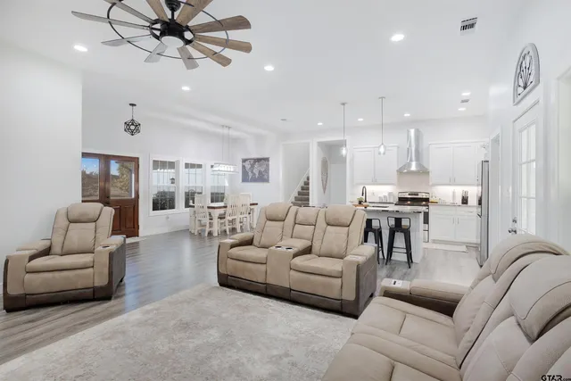 a living room with furniture kitchen view and a chandelier