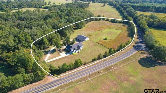 an aerial view of a house with yard basket ball court and outdoor seating