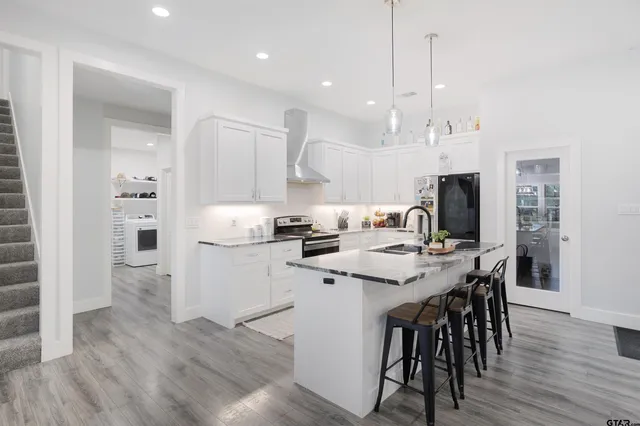 a kitchen with a dining table chairs refrigerator and cabinets