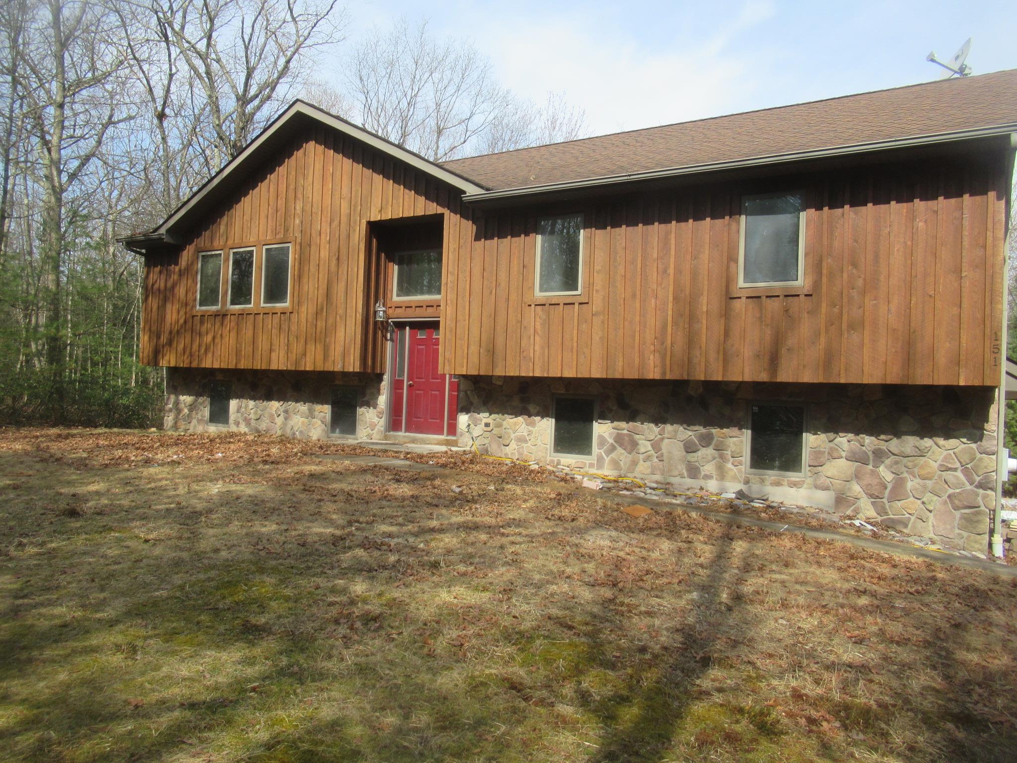 Raised ranch featuring stone siding