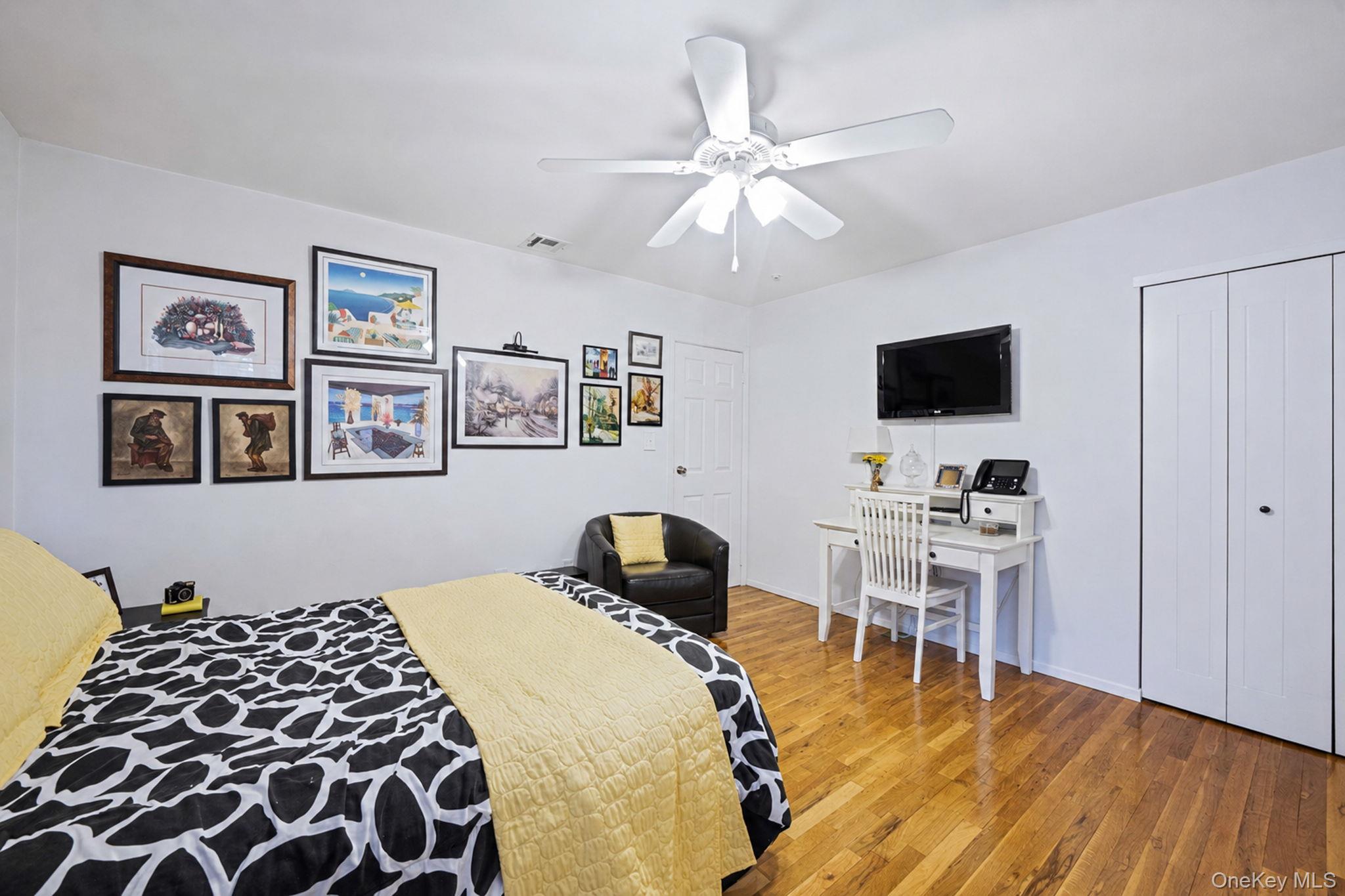 96 Fulton Boulevard Commack, NY 11725 - Photo 31 of 41 a bedroom with a bed and a flat screen tv