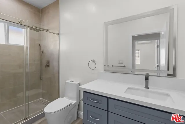 a bathroom with a sink toilet vanity and shower