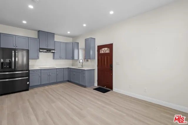 a kitchen with stainless steel appliances kitchen island granite countertop a refrigerator and a sink