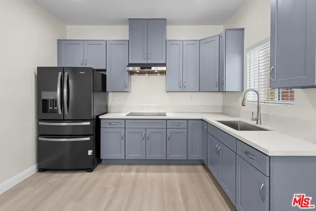 a kitchen with a refrigerator sink and cabinets