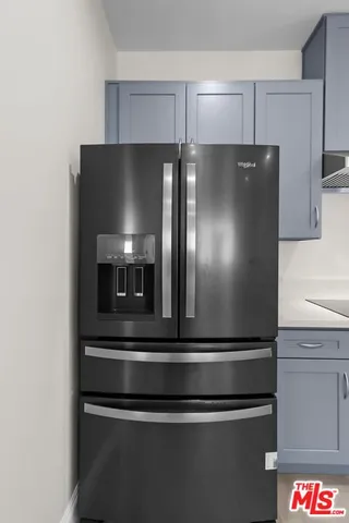 a metallic refrigerator freezer sitting in a kitchen