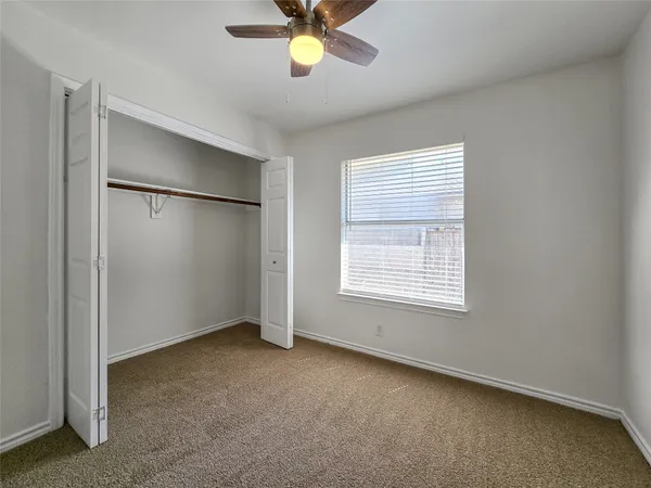 an empty room with closet and windows