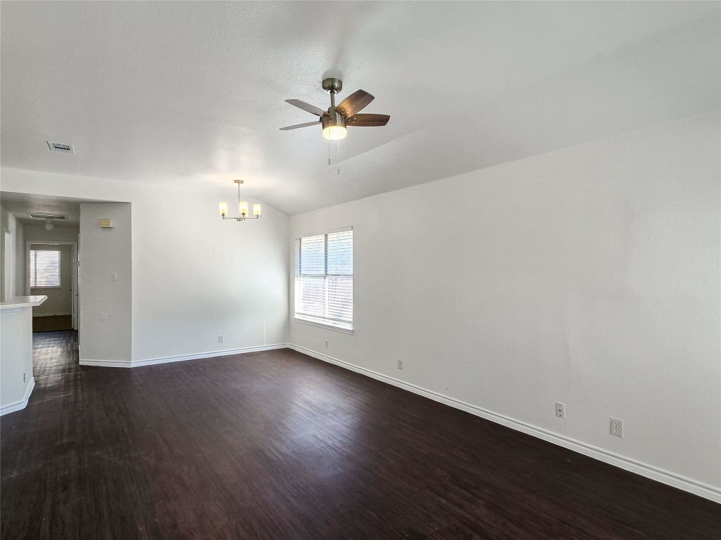 300 Tamara Drive, Unit B Georgetown, TX 78628 - Photo 5 of 16 an empty room with wooden floor chandelier fan and windows