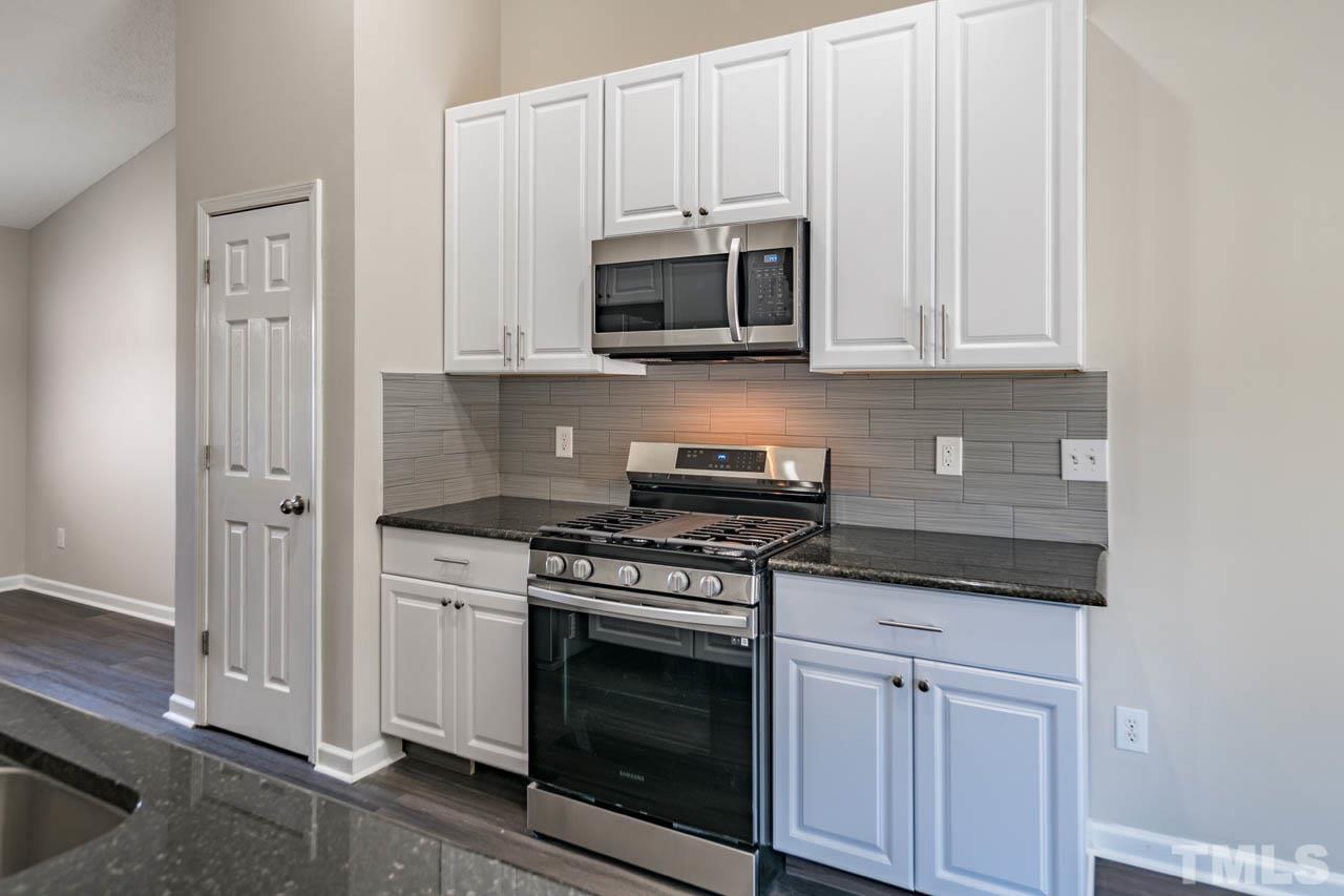 5016 Marathon Lane Raleigh, NC 27616 - Photo 8 of 27 a kitchen with stainless steel appliances granite countertop white cabinets and a stove top oven