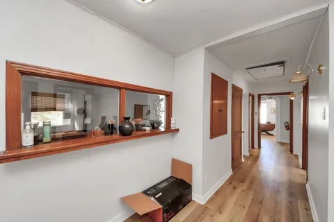a view of a living room and bedroom with wooden floor
