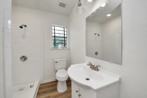 a bathroom with a sink a toilet and shower