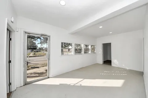 a view of an empty room with window and bathroom