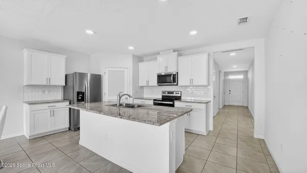 a kitchen with a sink a counter top space and cabinets