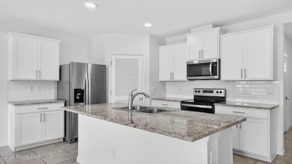 a kitchen with a sink and refrigerator