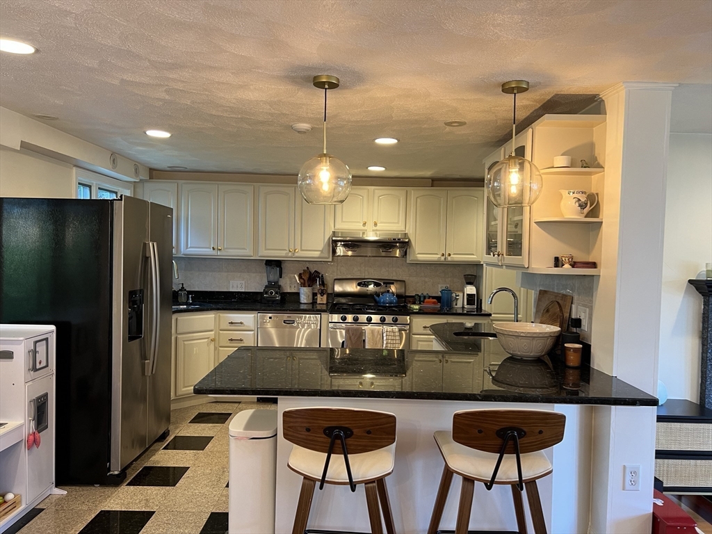 11 Garrison Road, Unit 1 Arlington, MA 02474 - Photo 2 of 42 a kitchen with refrigerator and chairs