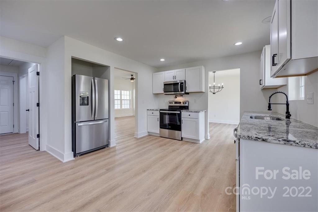 1009 Rainbow Circle Catawba, SC 29704 - Photo 11 of 21 a kitchen with kitchen island granite countertop stainless steel appliances a refrigerator cabinets and wooden floor