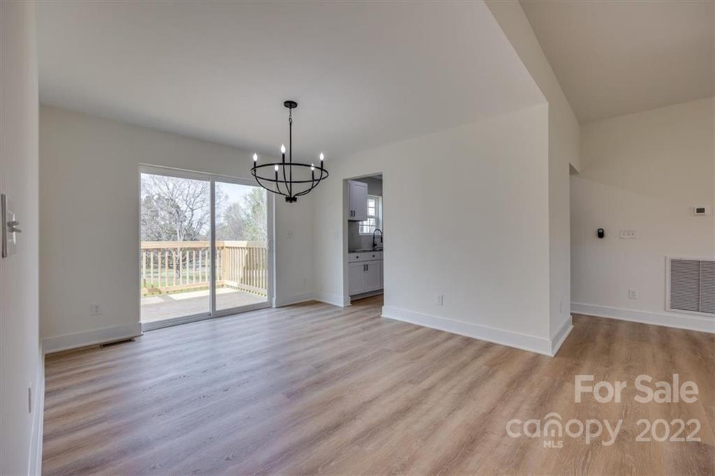 1009 Rainbow Circle Catawba, SC 29704 - Photo 4 of 21 an empty room with wooden floor chandelier and windows