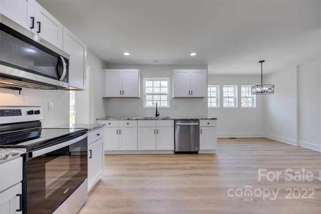 1009 Rainbow Circle Catawba, SC 29704 - Photo 9 of 21 a kitchen with stainless steel appliances kitchen island granite countertop a stove a sink and a microwave