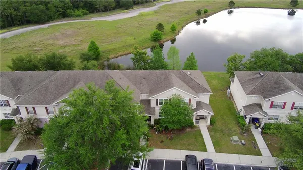 an aerial view of a house with a garden and lake view