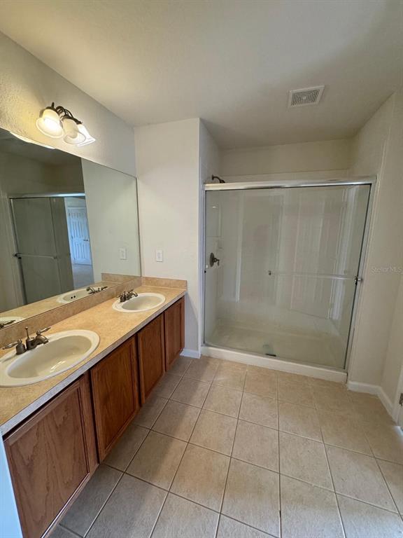 2543 Old Kent Circle Kissimmee, FL 34758 - Photo 13 of 41 a bathroom with a double vanity sink mirror and shower