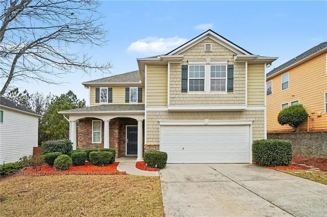 a front view of a house with a yard and potted plants