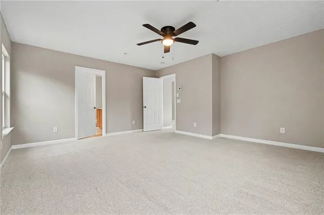 a view of an empty room with a ceiling fan