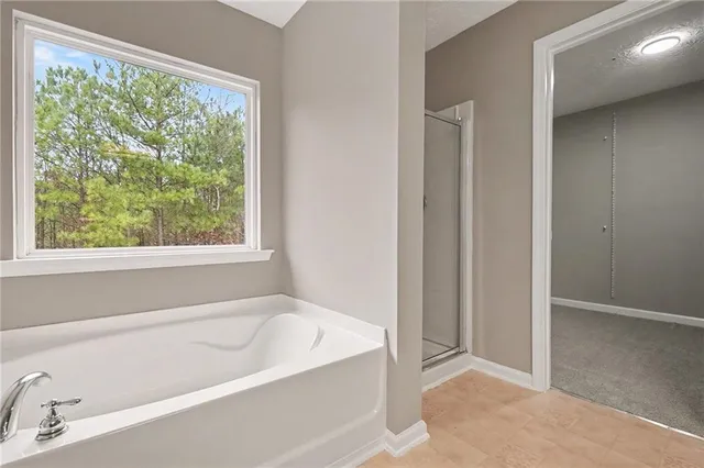a white bath tub sitting in a bathroom next to a window