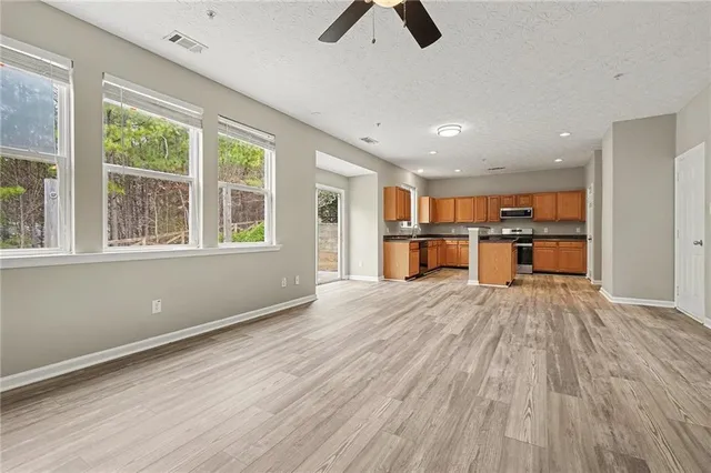 a view of empty room with wooden floor and window