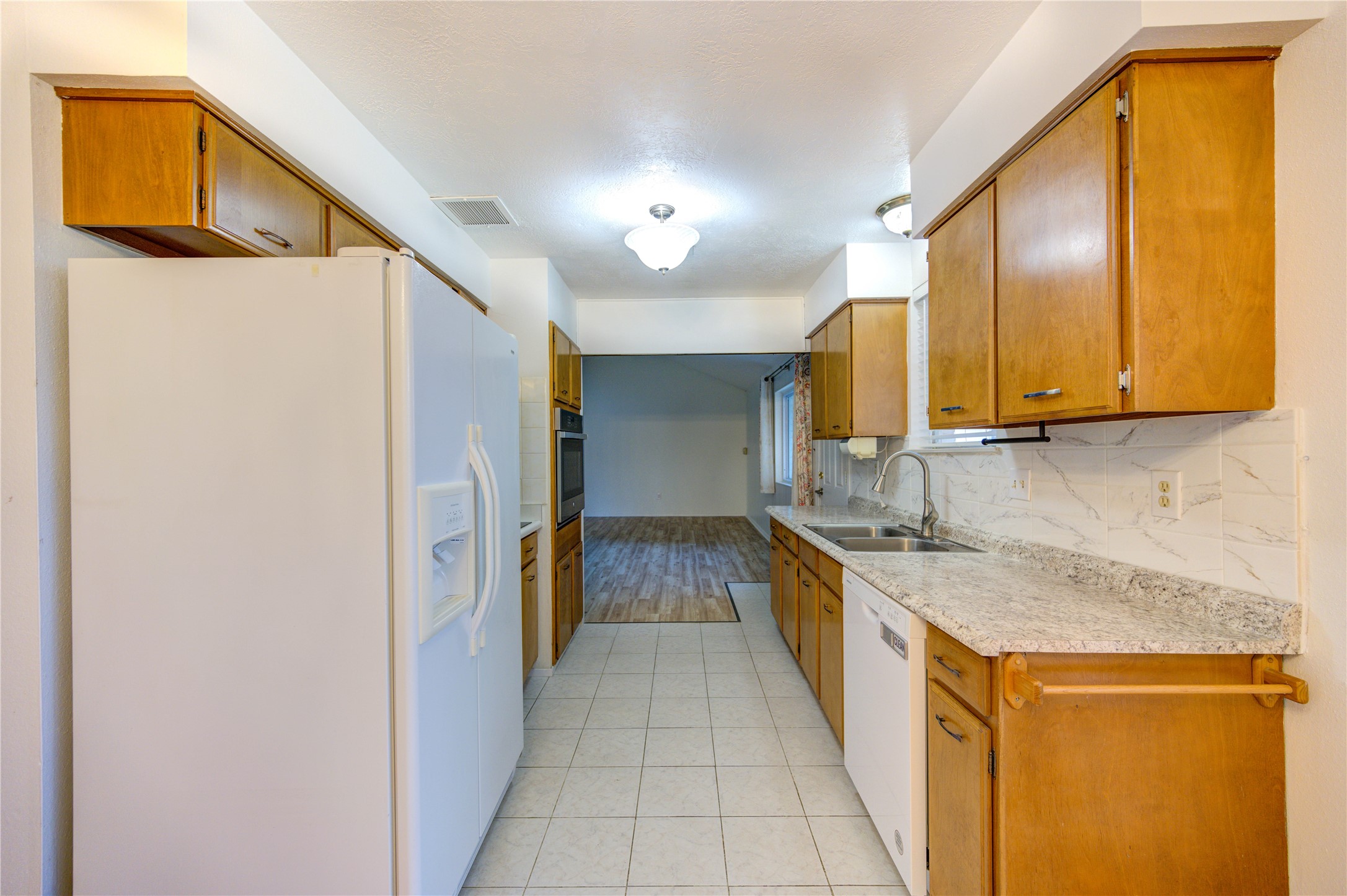 10823 Radford Lane Houston, TX 77031 - Photo 9 of 18 a kitchen with granite countertop a sink and a refrigerator