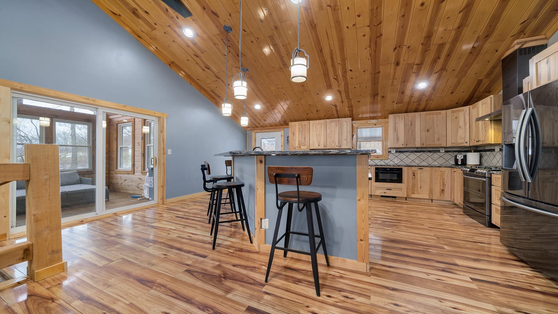 2063 Grand Detour Road Dixon, IL 61021 - Photo 4 of 44 a kitchen with stainless steel appliances kitchen island granite countertop a table chairs refrigerator and wooden floor