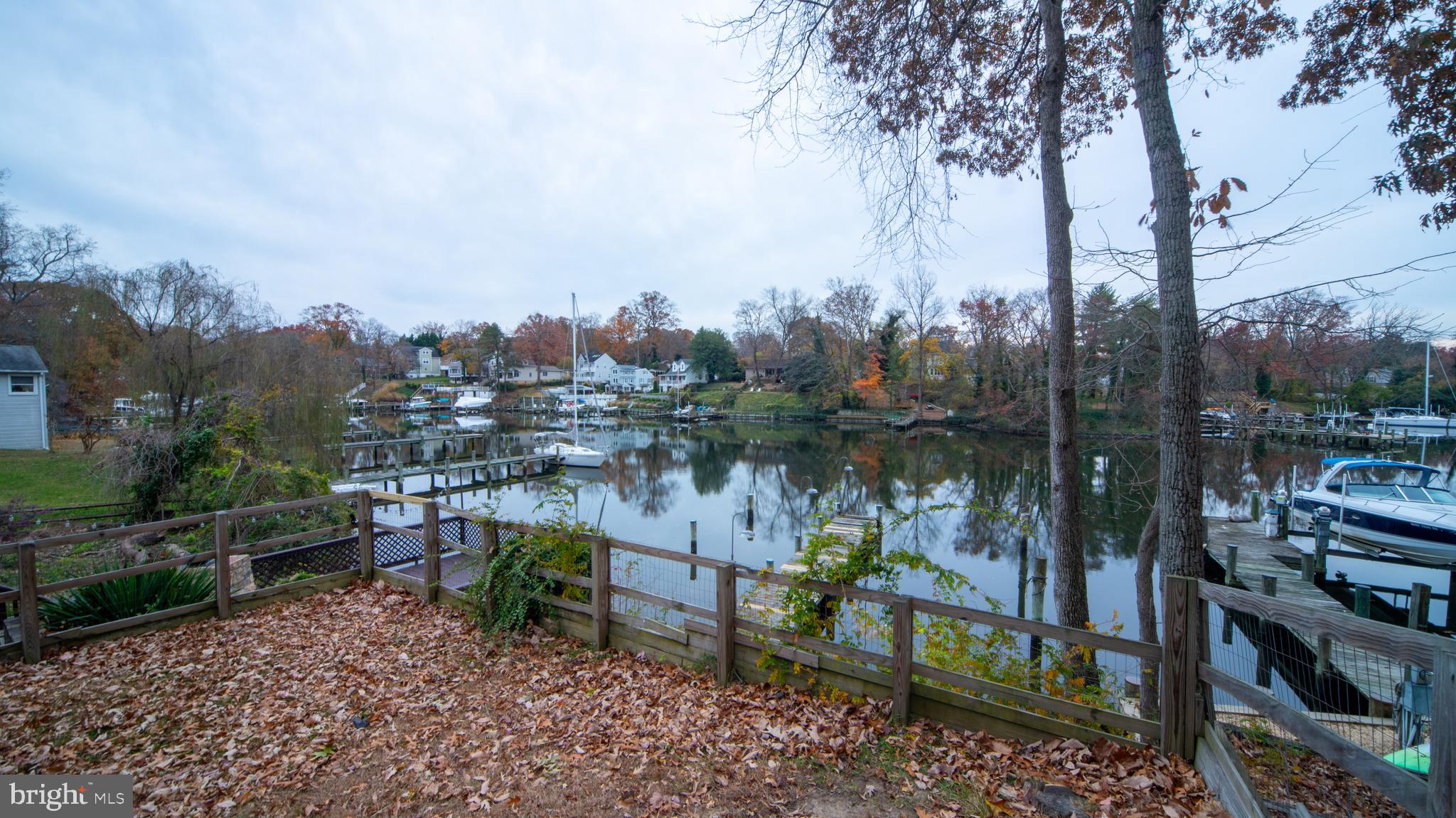 593 Riverside Drive Pasadena, MD 21122 - Photo 22 of 26 a view of a lake with a bench and lake view