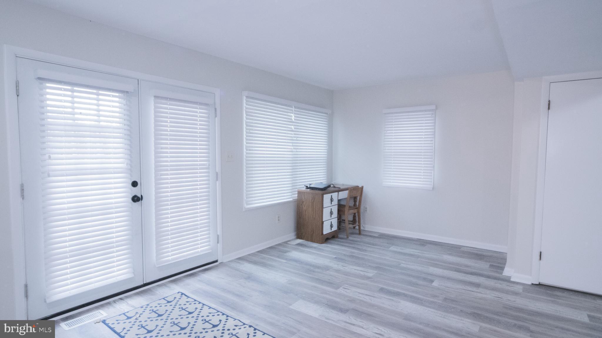 593 Riverside Drive Pasadena, MD 21122 - Photo 4 of 25 an empty room with wooden floor and windows