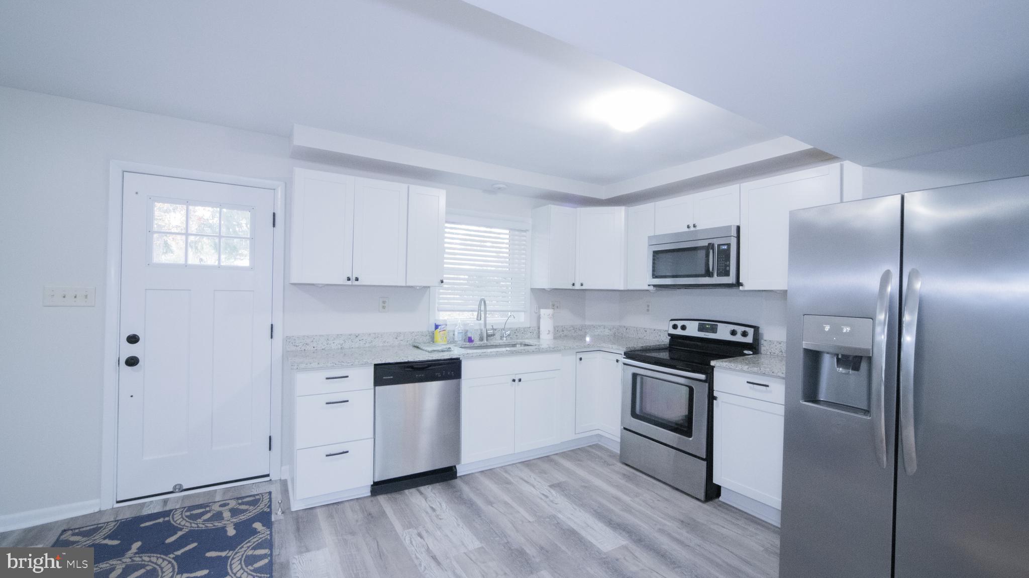 593 Riverside Drive Pasadena, MD 21122 - Photo 6 of 26 a kitchen with stainless steel appliances granite countertop a stove a sink and a refrigerator