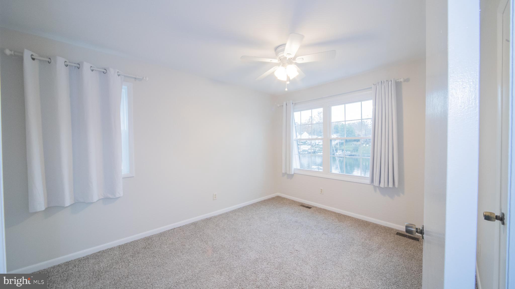 593 Riverside Drive Pasadena, MD 21122 - Photo 10 of 26 an empty room with windows and fan