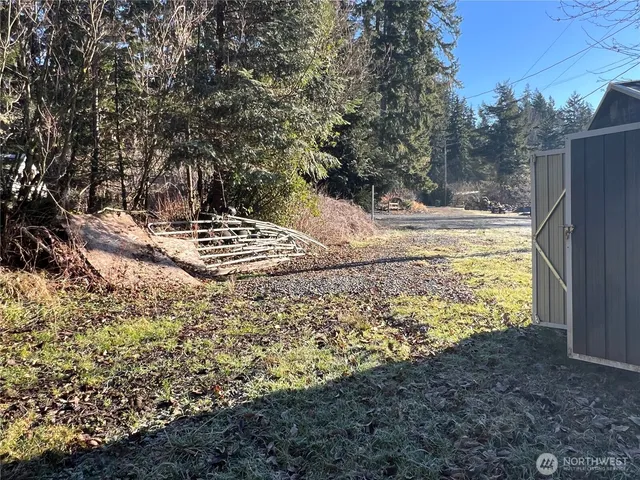 a view of a yard with wooden fence