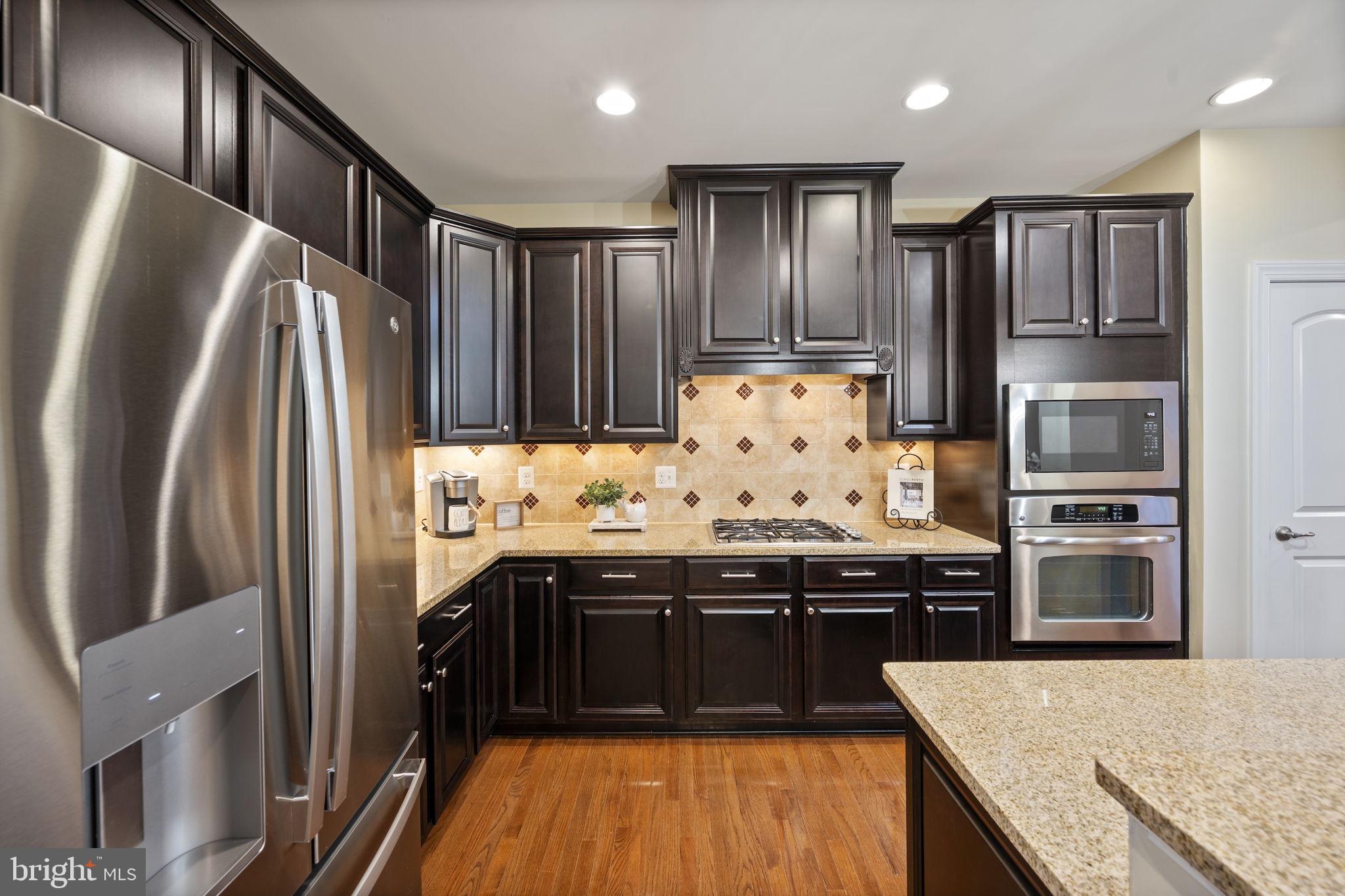8976 Tawes Street Fulton, MD 20759 - Photo 19 of 65 a kitchen with stainless steel appliances granite countertop a refrigerator a stove and a sink
