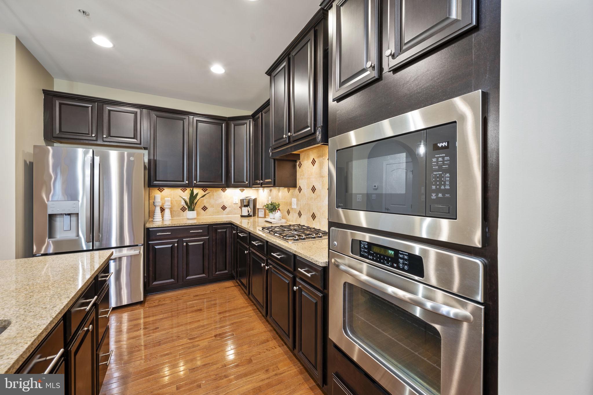 8976 Tawes Street Fulton, MD 20759 - Photo 20 of 65 a kitchen with stainless steel appliances granite countertop a refrigerator and a stove top oven
