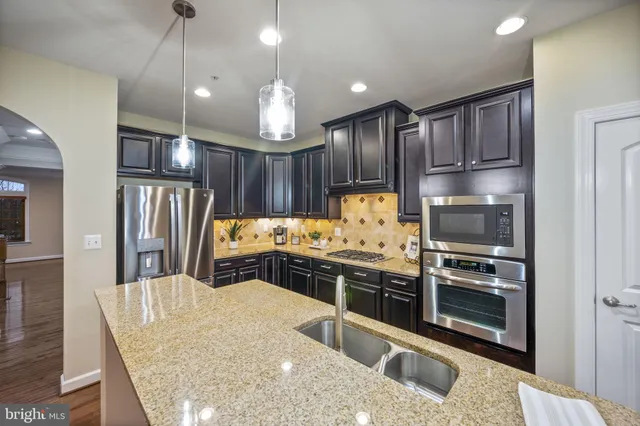 a view of kitchen with kitchen island and stainless steel appliances