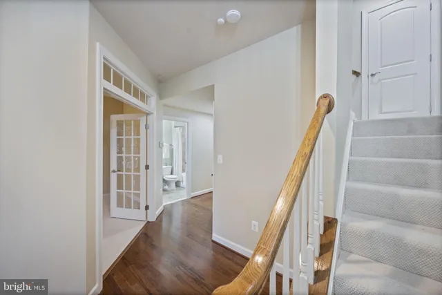 a view of a hallway with wooden floor and staircase
