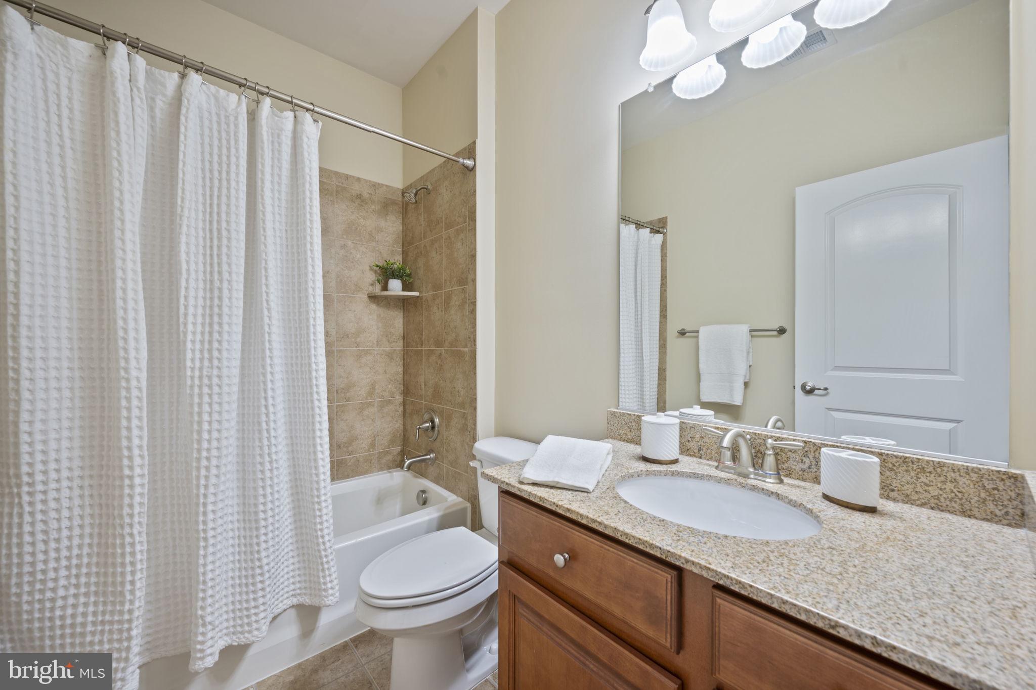 8976 Tawes Street Fulton, MD 20759 - Photo 47 of 65 a bathroom with a granite countertop sink toilet and shower