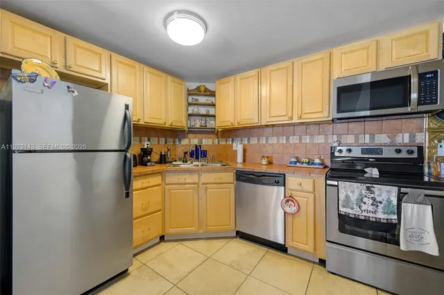 a kitchen with stainless steel appliances granite countertop a refrigerator stove top oven and sink