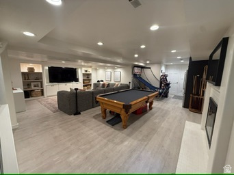 340 Willow Ridge Circle Centerville, UT 84014 - Photo 20 of 32 Recessed lighting, light wood-finish flooring, built-in media center, built-in shelving, and a white fireplace surround